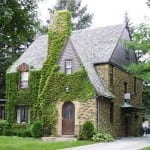 Ivy covered stone tudor. Note the slight flair of the roof at the soffit (a distinct dutch influence)