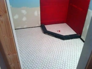 The bathroom floor tiled and the shower walls painted with RedGard waterproofer